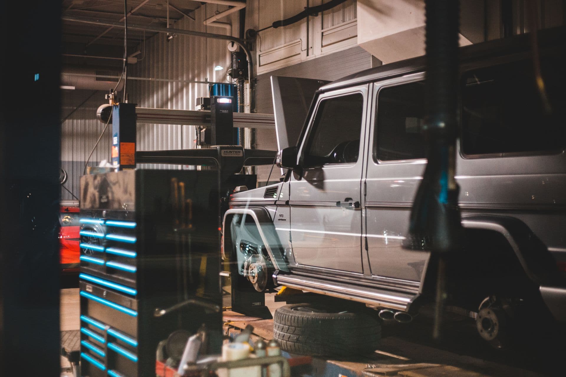 Technician working underneath a vehicle on the hoist